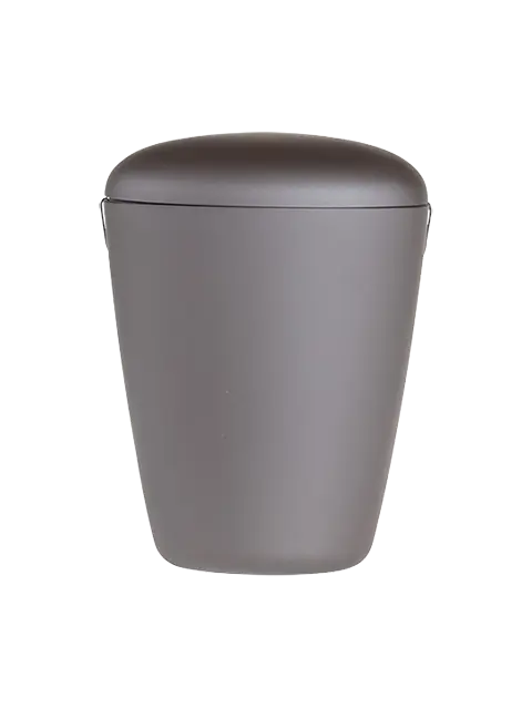 Heim Urne – En miljøvenlig og stilfuld løsning Heim er en ARB FORM urne, fremstillet af biologiske materialer uden brug af råolie. Den er 100% biologisk nedbrydelig og komposterbar, malet i en smuk sort farve. Den bløde velouroverflade er skabt med vandbaseret maling. Urnen har en unik trekantet form, som giver den et ikonisk og moderne udseende. Lille